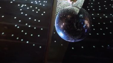 Tavandan sarkan gümüş ayna disko topu hızla döner, ışık huzmeleri ve parıldar. Konser salonunda, kulüpte, partide ya da diskoda beyaz sahne ışığı. Aydınlık ve atmosfer.