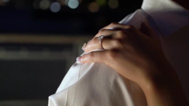 Romantik bir gecede, omuzda bir nişan yüzüğü taşıyan bir el aşk ve ilişki tasviri için ideal, aşk, ilişki ve romantik atmosfer gibi anahtar kelimelerle görülür.