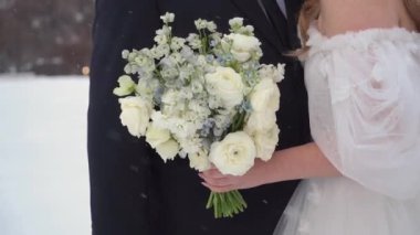 Resmedilmeye değer bir kış düğün sahnesi aşkın ve sofistike bir gelinin ve damadın özünü yakalar. Şık bir buketle, mevsimin güzellikleriyle çevrili özel günlerini kutlarlar.