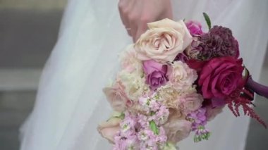 Elbise giymiş bir kadın elinde buket beyaz gül çiçekleriyle. Bir kadın için hediye, tatil, gelinin düğün buketi. Çiçekçilik. İçeride. Düğün günü peçeli gelin.