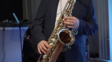 Saksafoncu müzik çalar. Saksafon çalan müzisyen. Rüzgar müzik aletleri - saksafon. Sanatçı sahnede, bando konserinde, caz festivalinde