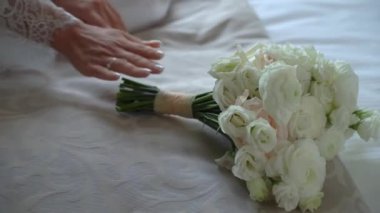 Elbise giymiş bir kadın elinde buket beyaz gül çiçekleriyle. Bir kadın için hediye, tatil, gelinin düğün buketi. Çiçekçilik. İçeride. Düğün günü peçeli gelin.