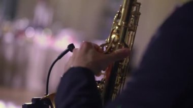 Saksafoncu müzik çalar. Saksafon çalan müzisyen. Rüzgar müzik aletleri - saksafon. Sanatçı sahnede, bando konserinde, caz festivalinde