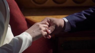 Gelin ve damat el ele tutuşuyor. Beyaz gelinlikli genç bir kadın ve takım elbiseli bir adam. Sevgi, ilgi ve şefkat. Birlikte.