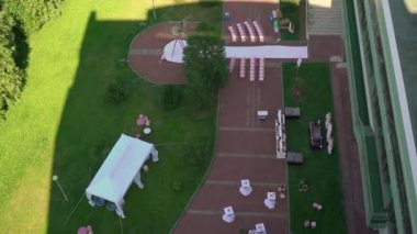 Çiçek ve sandalyeli düğün kemeri. Seremoni salonu açık havada. Beyaz çiçekler ve yeşilliklerle süslenmiş. Güneşli yaz günü.