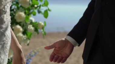 Gelin ve damat el ele tutuşuyor. Beyaz gelinlikli genç bir kadın ve takım elbiseli bir adam. Sevgi, ilgi ve şefkat. Birlikte.