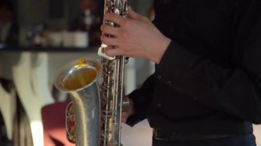 Saksafoncu müzik çalar. Saksafon çalan müzisyen. Rüzgar müzik aletleri - saksafon. Sanatçı sahnede, bando konserinde, caz festivalinde