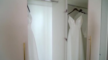 Odadaki askıda asılı beyaz bir gelinlik. Gelinin sabahı. Lüks kadın elbiseleri yatak odasında. Aşk ve evlilik.