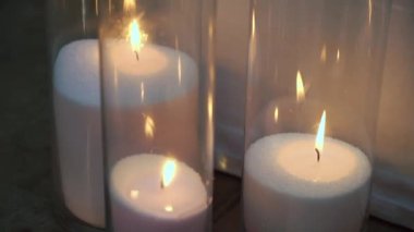 Dekoratif beyaz mumlar, yerde şeffaf cam şişeler ve şamdanlar var. Romantik atmosfer. Düğün, doğum günü ya da diğer tatiller için dekorasyon. Noel.
