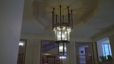 Şatafatlı restoranların, otellerin ya da sarayların tavanında asılı cam kristaller ve yapay elmaslarla iç aydınlatma lambaları..