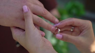 Gelin ve damat düğün töreninde. Adam bir kadın parmağına yüzük taktı. Takı yüzükleri, aşkın sembolü..