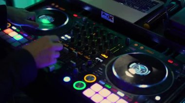 NEW YORK, ABD - 9 Mayıs 2024: Canlı bir karıştırma konsoluna bir DJ 'in elleri yakın plan, renkli düğmeler ve turntable' lar, müzik ve gece hayatı temaları için mükemmel