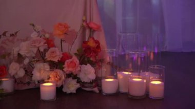 Dekoratif beyaz mumlar, yerde şeffaf cam şişeler ve şamdanlar var. Romantik atmosfer. Düğün, doğum günü ya da diğer tatiller için dekorasyon. Noel.