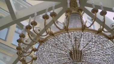 Şatafatlı restoranların, otellerin ya da sarayların tavanında asılı cam kristaller ve yapay elmaslarla iç aydınlatma lambaları..