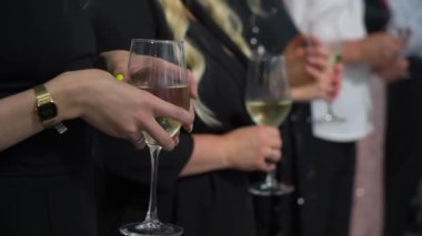 Elinde bir kadeh şampanya tutan biri. Alkollü içecekle ya da içecekle kutlama - beyaz köpüklü şarap.