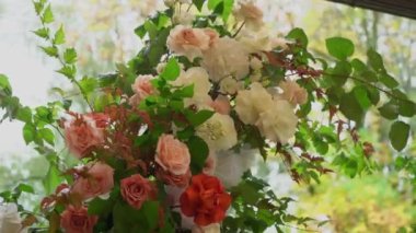 Çiçek ve sandalyeli düğün kemeri. Seremoni salonu açık havada. Beyaz çiçekler ve yeşilliklerle süslenmiş. Sonbahar bulutlu günü.