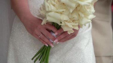 Elbise giymiş bir kadın elinde buket beyaz gül çiçekleriyle. Bir kadın için hediye, tatil, gelinin düğün buketi. Çiçekçilik. İçeride. Düğün günü peçeli gelin.