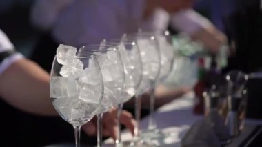 Garson ya da barmen bardakla kokteyl karıştırıyor. Bir kutlamada ya da bir restoranda ya da tatil barında hoş geldin içkisi. Alkollü içecek. Saman içmek.