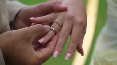 Gelin ve damat düğün töreninde. Adam bir kadın parmağına yüzük taktı. Takı yüzükleri, aşkın sembolü..