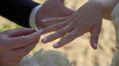 Gelin ve damat düğün töreninde. Adam bir kadın parmağına yüzük taktı. Takı yüzükleri, aşkın sembolü..