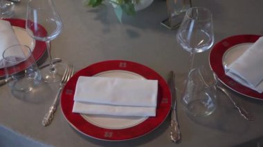 Gözlüklü ve tabaklı bir düğün resepsiyonu için masa ayarlama. Kapalı resepsiyon salonu.