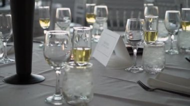 Ziyafet masası güzel bir şekilde şarap kadehleri ve peçetelerle süslenmiş, düğünler, resmi yemekler ve özel kutlamalar için ideal. Zarafet yayar ve sofistike olaylar için mükemmeldir.