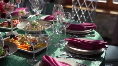 Gözlüklü ve tabaklı bir düğün resepsiyonu için masa ayarlama. Kapalı resepsiyon salonu.