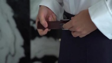 Siyah takım elbiseli ve beyaz gömlekli bir adam deri kemer taktı. Erkek giyimi. Düğün gününde işadamı ya da damat gibi giyinmek. Tanınmayan kişi.