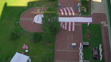 Çiçek ve sandalyeli düğün kemeri. Seremoni salonu açık havada. Beyaz çiçekler ve yeşilliklerle süslenmiş. Güneşli yaz günü.