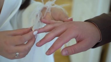 Gelin ve damat düğün töreninde. Adam bir kadın parmağına yüzük taktı. Takı yüzükleri, aşkın sembolü..