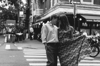 Bir çift sevgi dolu bir kucaklaşmayı paylaşıyor yemyeşil bir yeşilliğin önünde, derin aşkın mahrem anlarını yakalıyorlar.