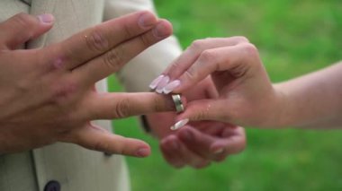 Gelin ve damat düğün töreninde. Adam bir kadın parmağına yüzük taktı. Takı yüzükleri, aşkın sembolü..