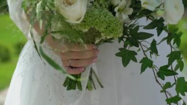 Elbise giymiş bir kadın elinde buket beyaz gül çiçekleriyle. Bir kadın için hediye, tatil, gelinin düğün buketi. Çiçekçilik. İçeride. Düğün günü peçeli gelin.