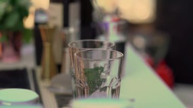 Garson ya da barmen bardakla kokteyl karıştırıyor. Bir kutlamada ya da bir restoranda ya da tatil barında hoş geldin içkisi. Alkollü içecek. Saman içmek.