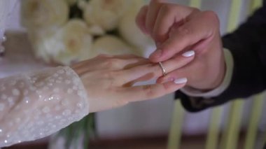 Gelin ve damat düğün töreninde. Adam bir kadın parmağına yüzük taktı. Takı yüzükleri, aşkın sembolü..