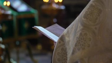 Rahip İncil 'i ya da İncil' i tutar ve dua okur. Hıristiyanlık ya da Katoliklik, Tanrı 'ya inanç. Kilise ayini, ayin..