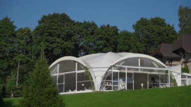 Tarlada beyaz bir çadır. Düğün ve etkinlikler için Pavilion resepsiyon yeri. Açık havada yaz günü.