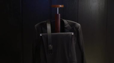 Modern bir askıda güzel bir şekilde sergilenen şık siyah takım elbise, moda ve tasarım için ideal.