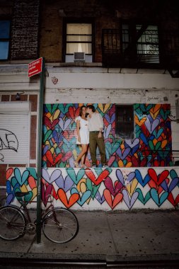 Canlı bir kalbin önünde birkaç öpücük. Canlı bir şehir ortamında aşklarını sembolize ediyorlar.