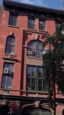 Canlı bir şehir manzarası içinde klasik mimariyi güzel gösteren büyüleyici bir kırmızı tuğla bina cephesi