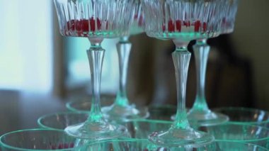 Aydınlatılmış cam bardaklardan oluşan sanatsal bir düzenleme. Taze ahududu dolu. Şenlik için mükemmel.