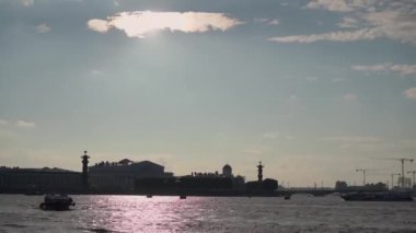 Suyun üzerinde, Saint-Petersburg 'da canlı gökyüzüne vurgulanmış güzel, sakin bir günbatımı.