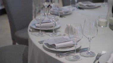 Lezzetli bir yemek deneyimi için nefis cam eşyalar ve zarif çatal bıçaklarla güzel bir yemek masası.