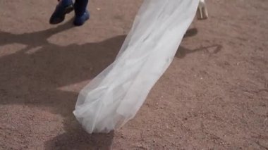 Bu gerçekten çok güzel bir fotoğraf. Akan gelinliği mükemmel bir şekilde yakalıyor. Sevgi dolu çift birlikte yürürken.