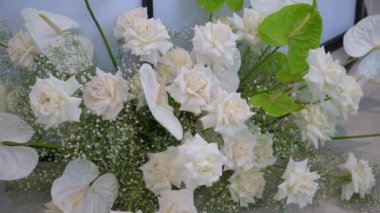 Bu çarpıcı çiçek aranjmanı beyaz güller ve yemyeşil renkler içerir.