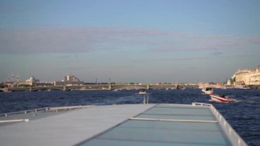 Küçük bir tekne, güneşli bir günde huzurlu ve sakin bir su yolunda yol alır. Saint-Petersburg 'da sakin bir manzara yaratır.