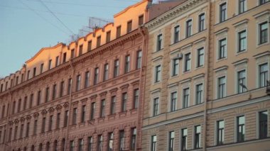 Tarihi binaların çarpıcı cepheleri gün batımının sıcak altın ışığında güzelce yıkanır.