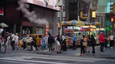 NEW YORK, ABD - 19 Mayıs 2024: Times Meydanı 'nda canlı ve hareketli bir sahne, çeşitli kalabalıklar, parlak reklamlar ve ikonik sarı taksiler