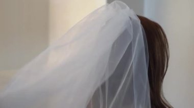 Güzel bir an, duvağını düzelten, aşkı ve heyecan verici yeni başlangıçları simgeleyen ışıl ışıl bir gelini yakalıyor.