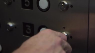 Bir el asansör düğmesini çalıştırmak için anahtar kullanıyor. Bu da binanın istenilen katına erişim sağlıyor.
